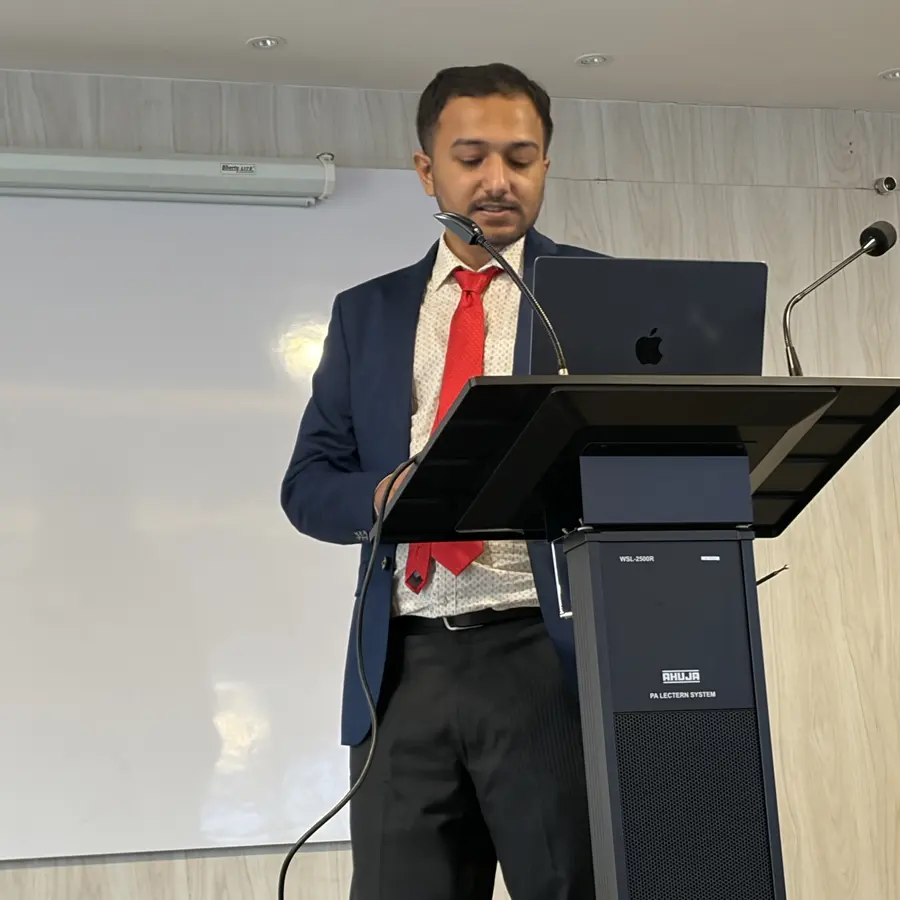 Souvik Ghosh at a podium with a laptop, giving a talk.