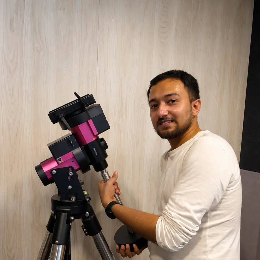 Souvik Ghosh adjusting a telescope mount on a tripod.